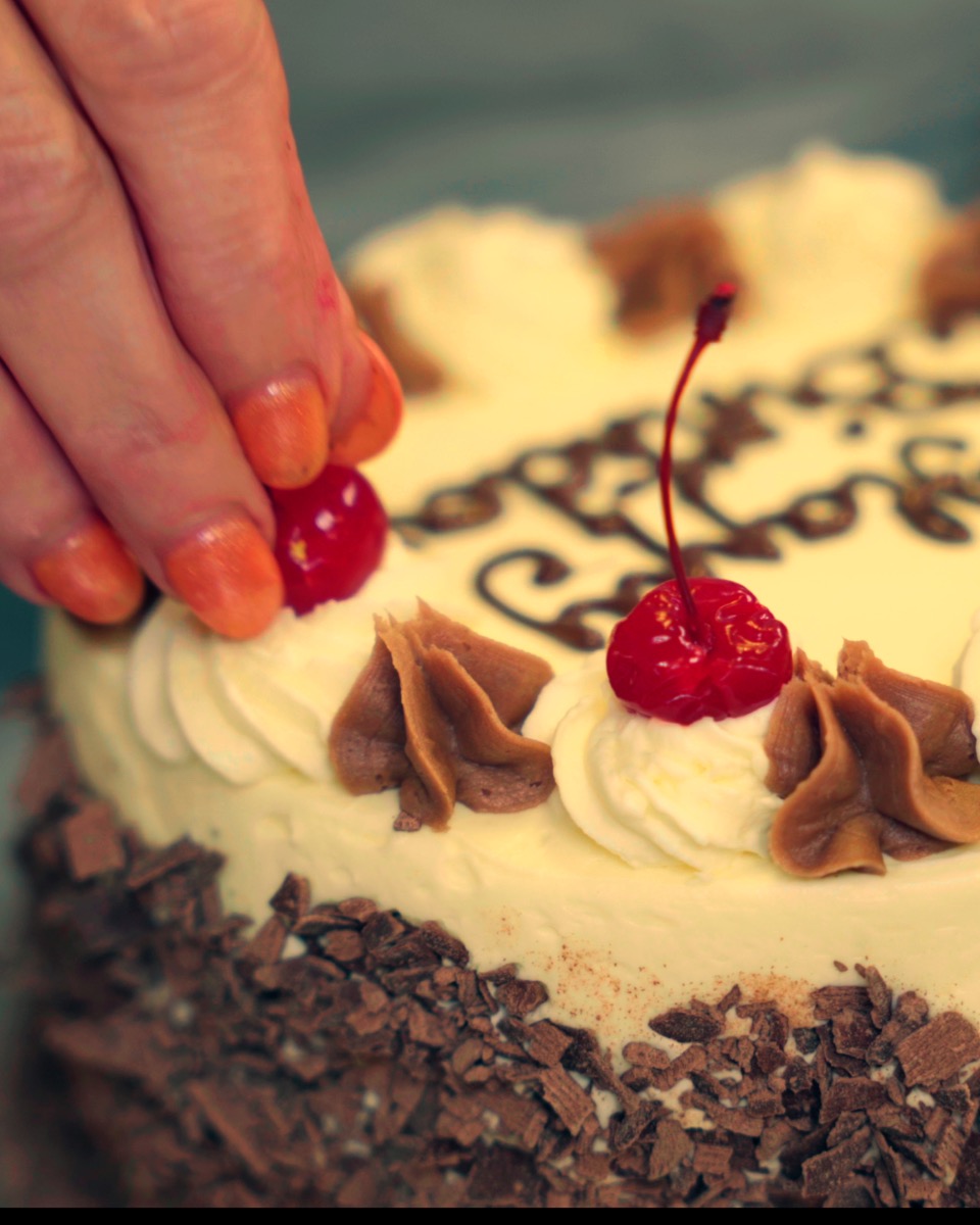 Decorating a cake with cherries